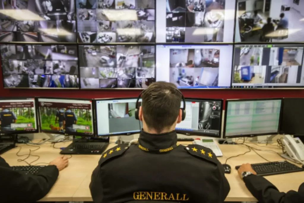 Vigilante monitorando câmeras de segurança de condomínio com portaria inteligente