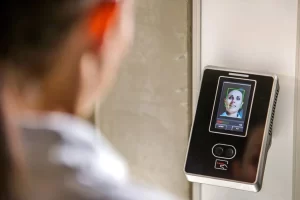 Mulher em frente a equipamento de reconhecimento facial para validar seu acesso a prédio