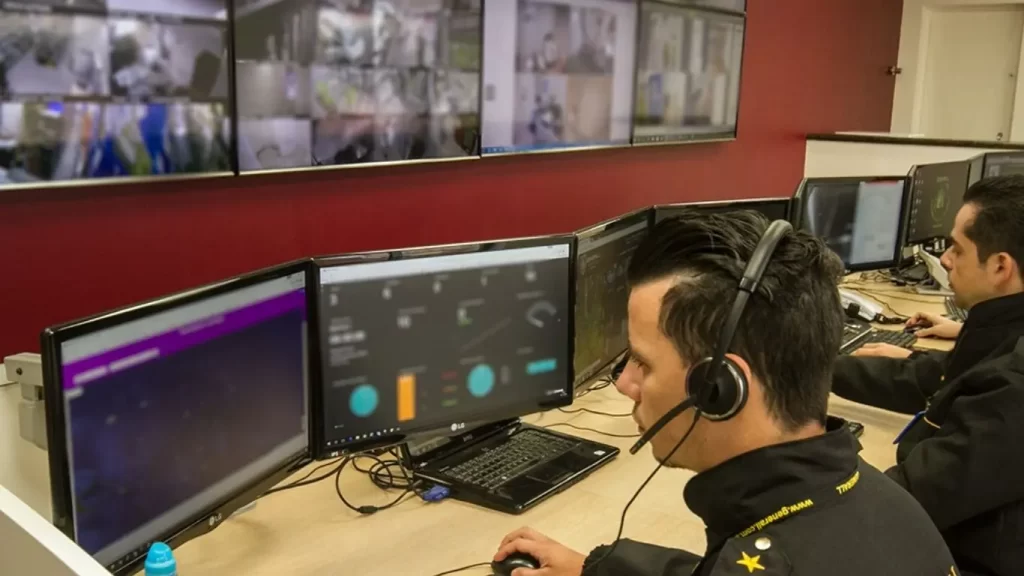 Central de monitoramento de câmeras trabalha com vigilantes, ilustrando vigilância física e eletrônica