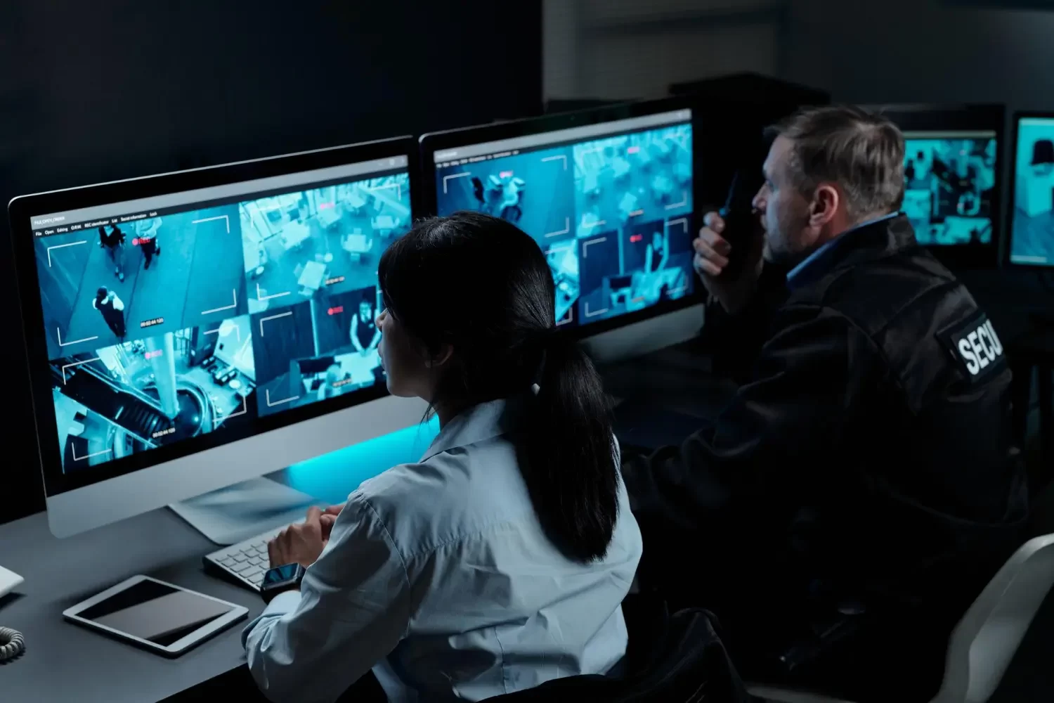 Oficiais analisando monitores de câmeras de segurança integrada